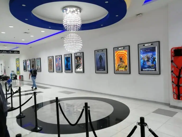 Foto eines Kinos in einem Einkaufszentrum in Kolumbien, an dessen Wänden Filmplakate hängen, mit moderner Beleuchtung und Wartebereichen für die Zuschauer.