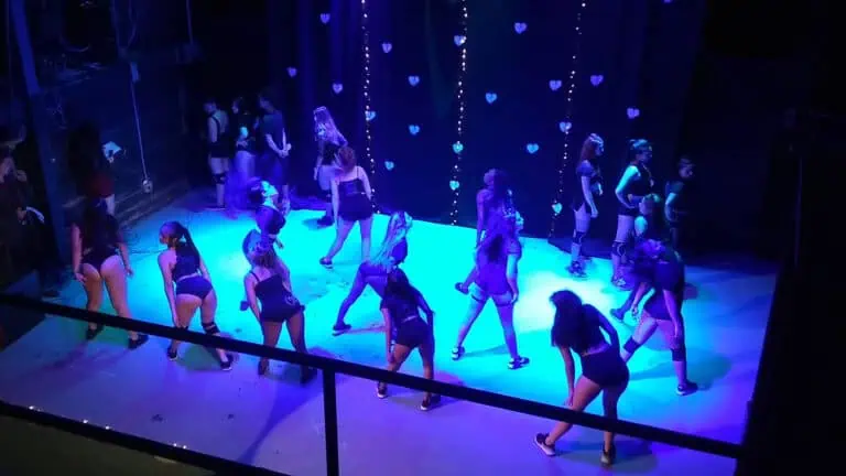 Dancers on a live event stage with blue lighting and heart decorations for live events in Colombia.