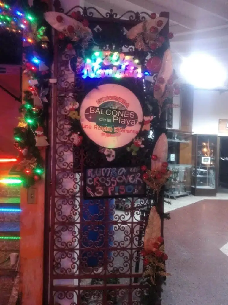 Beach balconies decorated with Christmas lights and event announcements, ideal for beach parties, with a festive atmosphere, music, and fun in a unique space.