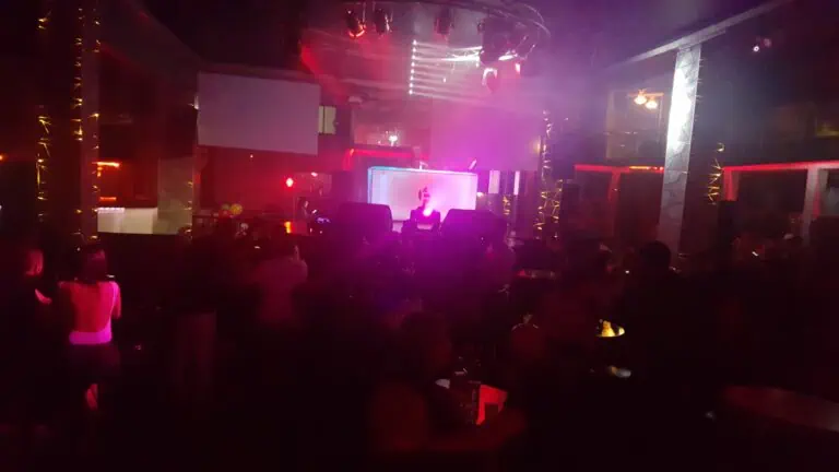 顾客们在一家设有LED灯光和舞台屏幕的夜总会里享受着精彩的活动。现代而优雅的空间里，气氛活跃，还有现场音乐表演。