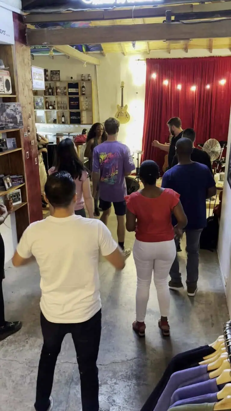 Profiter d'un événement dans un espace à thématique musicale et artistique, où plusieurs personnes interagissent et participent à des activités culturelles dans un environnement accueillant et bien éclairé.