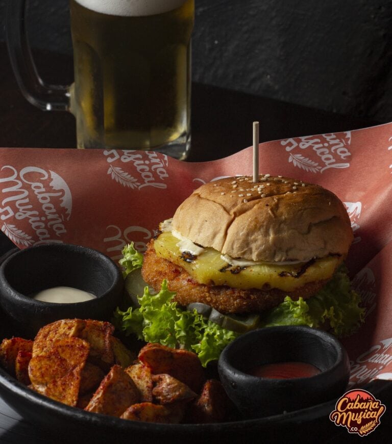 Sabores de comida rápida: deliciosa hamburguesa con papas fritas y salsa, acompañada de cerveza fría en un ambiente de restaurante. Perfecto para eventos y reuniones sociales.