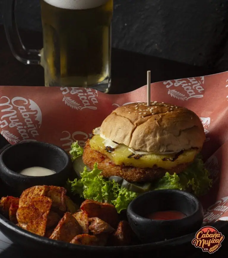 Fast-Food-Geschmäcker: leckerer Burger mit Pommes und Sauce, dazu kühles Bier im Restaurant-Ambiente. Perfekt für Events und gesellige Zusammenkünfte.