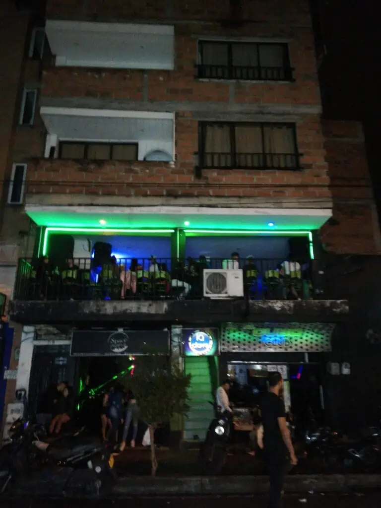 Variedad de eventos y entretenimiento en un bar con iluminaci&oacute;n LED en la terraza, ambiente nocturno, m&uacute;sica en vivo, y clientela disfrutando en un entorno urbano y vibrante.