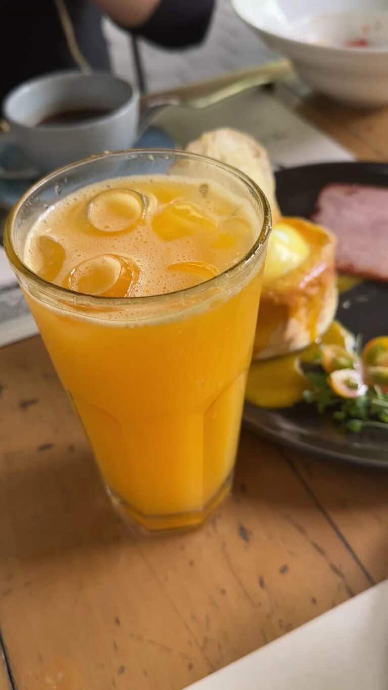 Jugo de naranja fresco en vaso alto con hielo, desayuno saludable en evento de café y desayuno.