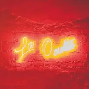 Lá Oita neon en pared de ladrillo roja, decoración moderna para eventos en Colombia.