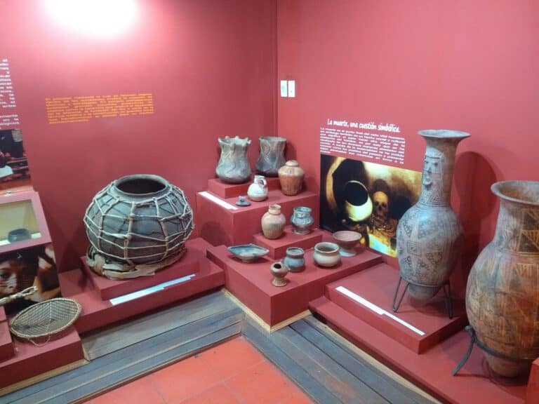 Artefactos precolombinos en exhibición en un museo, con cerámicas y vasijas de culturas antiguas, en un espacio cultural dedicado a la historia ancestral.