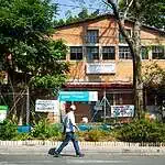 在波哥大洛斯阿尔卡萨雷斯文化中心的一条街道上，有一个社区花园，里面有信息牌，还有一名男子在走动，旨在推广波哥大的美食、文化和都市农业。