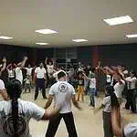 在封闭空间内进行的卡波耶拉儿童团体活动中，在面向儿童和成人的社区活动工作坊中展示动作和协调性。