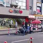 波哥大红宫购物中心，商店和饰品店入口，街上有人行走，一辆摩托车，背景是商铺。