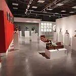 Modern art and sculptures on display at an art gallery in Colombia, featuring artistic lighting and arrangement on white pedestals.