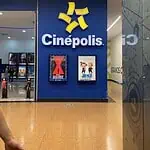 购物中心内的 Cinépolis 影院及电影列表。图片展示了影院入口，配有数字招牌和 Cinépolis 标志，环境现代且维护良好。