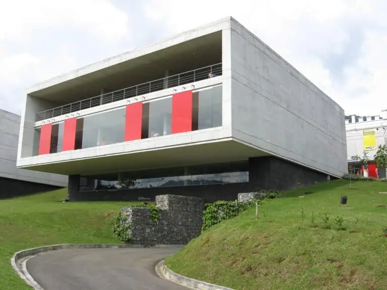 位于哥伦比亚创新型城市开发项目中的现代化活动和会议建筑，具有现代建筑设计、大窗户和户外草坪区。