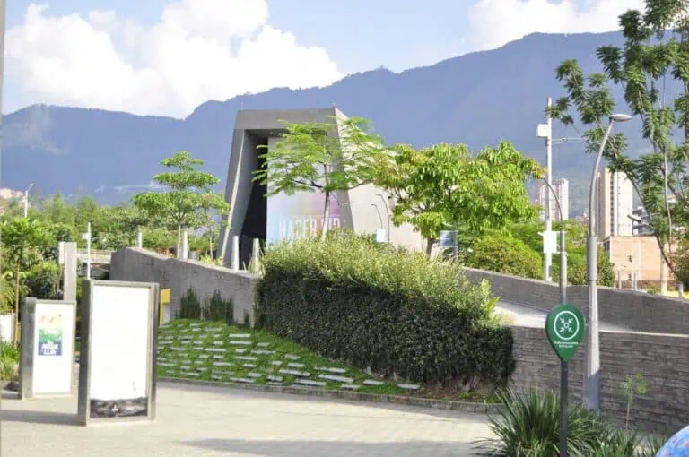 Een innovatief gebouw in een natuurlijke omgeving met bergen en groene gebieden op de achtergrond in de stad Medellín, Colombia, dat duurzame evenementen en technologie promoot.