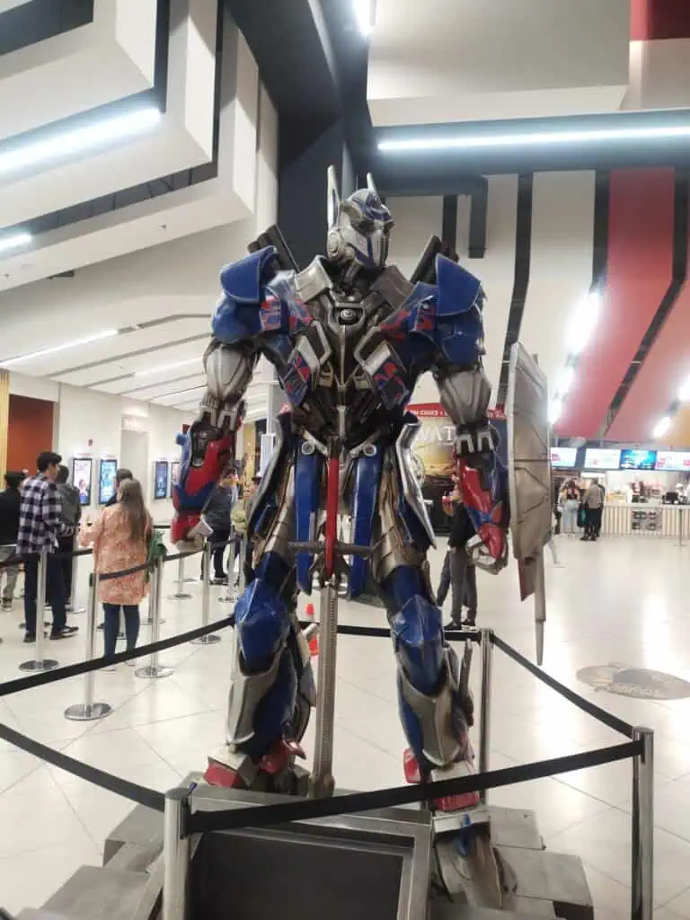 Robots géants exposés lors d'un événement technologique. Image haute qualité d'une figurine Transformers dans un centre commercial ou un salon technologique, idéale pour la promotion d'événements et les annonces technologiques.