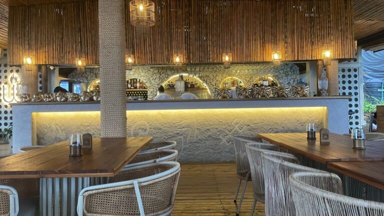 Bar de hotel con decoración moderna y cálida, muebles de madera y iluminación suave, ideal para eventos y reuniones en un ambiente sofisticado y acogedor en Colombia.