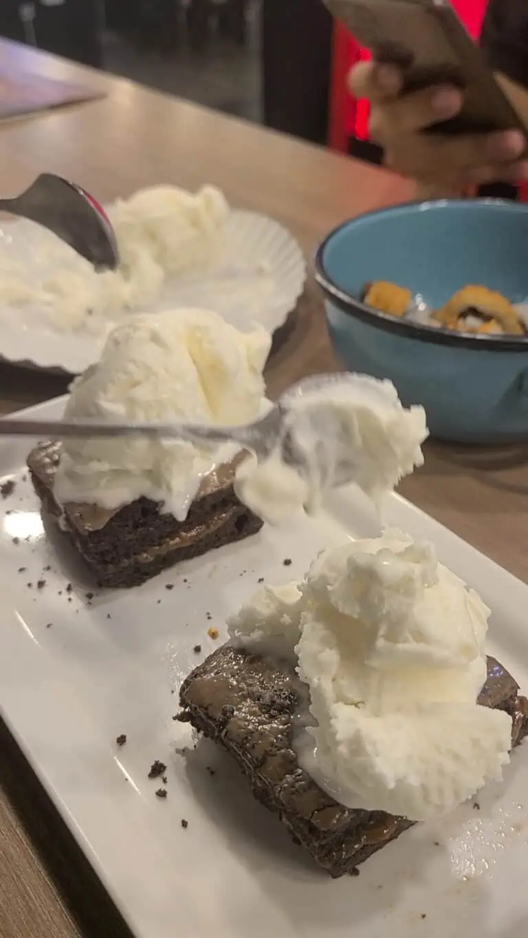 Délices de dessert avec glace à la vanille et brownies au chocolat sur une assiette blanche.