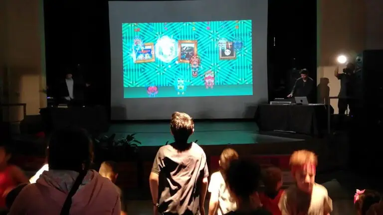 Spieler genießen ein interaktives Spiel bei einer Veranstaltung mit Großbildprojektion, lebendiger Atmosphäre und modernster Technologie für Kinder- und Familienunterhaltung.