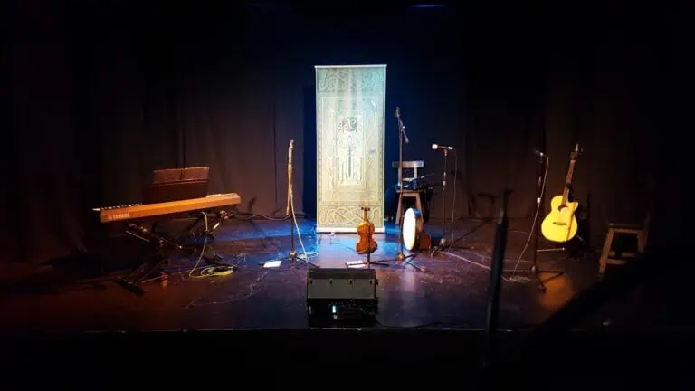 麦克风、乐器和音响设备已准备就绪，可在昏暗的舞台上为活动或音乐会做好准备，营造热情专业的现场表演氛围。