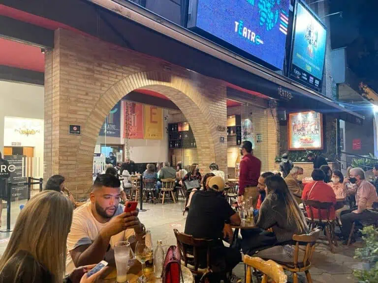 - Uno spazio vivace sulla terrazza di un ristorante o di un bar a Bogotà, pieno di clienti che si godono drink e cibo in una vivace atmosfera notturna.