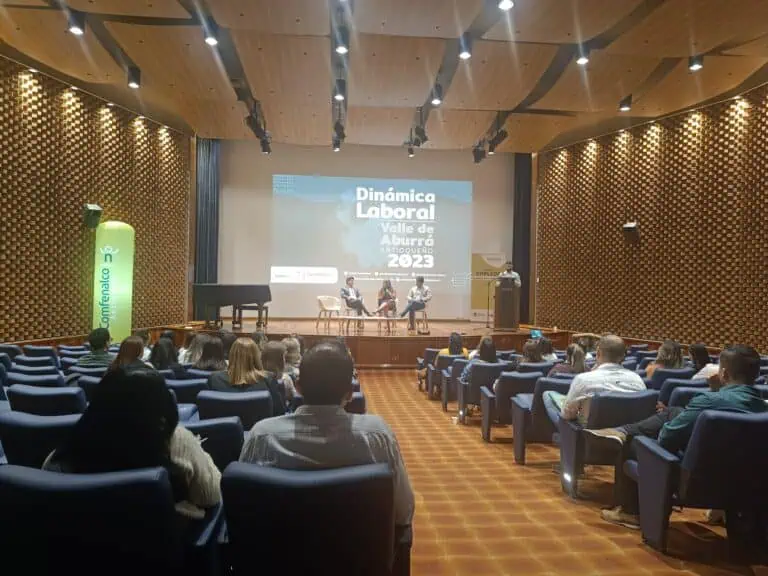 Eine innovative Schulungs- und Networking-Veranstaltung in einer modernen Halle, bei der die Teilnehmer an der Konferenz zur Arbeitskräftedynamik 2023 im Valle de Aburrá teilnehmen, die von Comfama Antioquia organisiert wird.