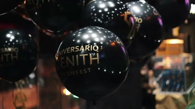 Balões pretos com a inscrição "Celebrando o aniversário da Zenith" em um evento; decoração para aniversários e comemorações corporativas; celebração do aniversário da Zenith em um ambiente festivo.
