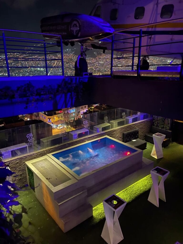 Esquina de jacuzzi en un ático con vista nocturna a la ciudad iluminada en Medellín, ideal para eventos exclusivos y experiencias de alojamiento premium.