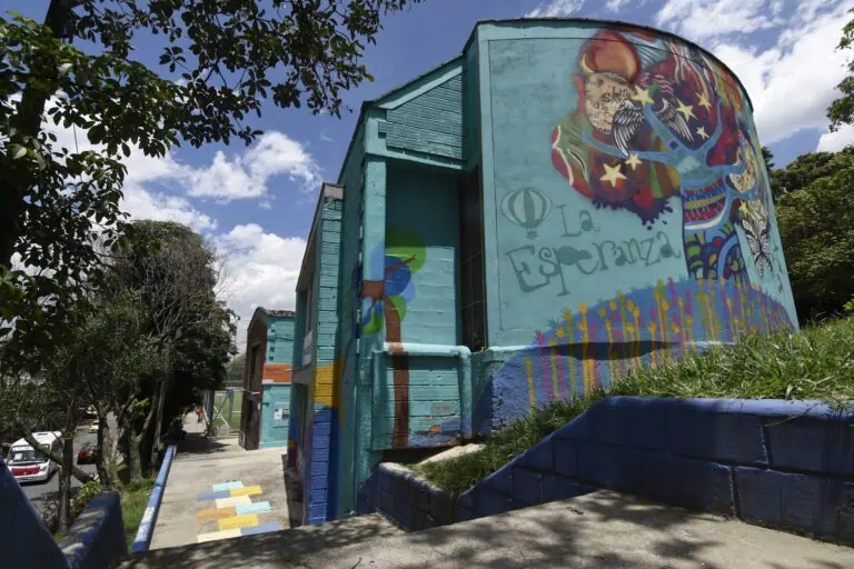Une fresque murale extérieure colorée représentant des symboles de paix et d'espoir reflète l'art et la culture urbains dans les espaces publics de Bogotá.