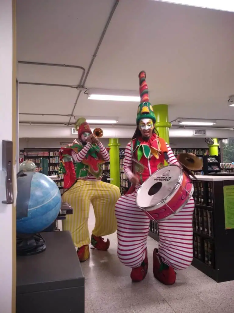 在图书馆举办的音乐活动中，小丑们演奏乐器，活跃气氛，促进公共场所的文化艺术活动。