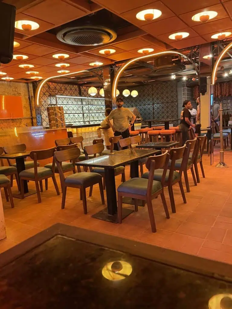 Table de restaurant avec chaises en bois et ambiance moderne et chaleureuse, idéale pour événements et réunions en Colombie.