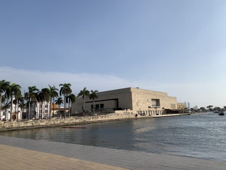 Modern museo en la costa con palmeras y vista al río, escenario perfecto para eventos y conferencias en Cartagena, Colombia. Diseño arquitectónico contemporáneo en un entorno turístico.
