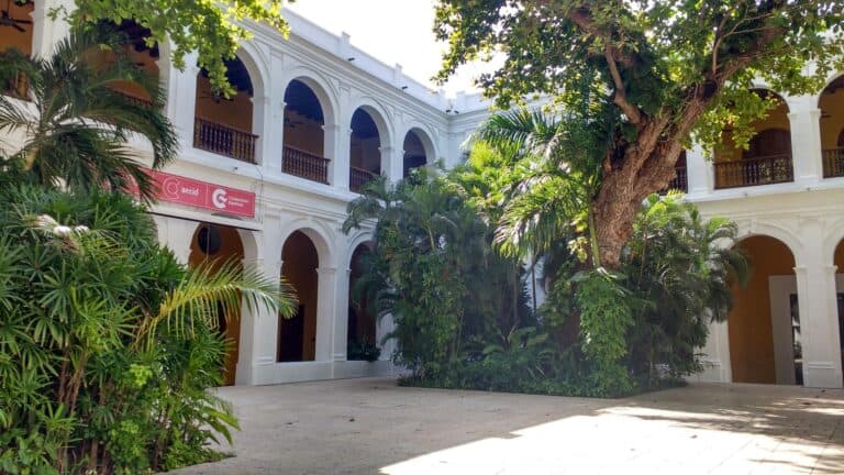 Atractivo edificio colonial con patios y jardines verdes, ideales para eventos y reuniones empresariales en un ambiente histórico y elegante.