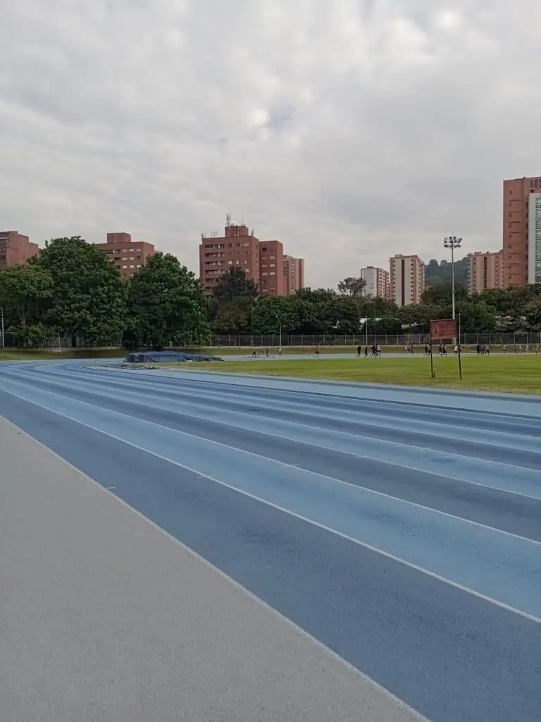 城市体育中心内的田径跑道，周围环绕着住宅楼和绿地。为城市环境中的训练和体育赛事提供空间。