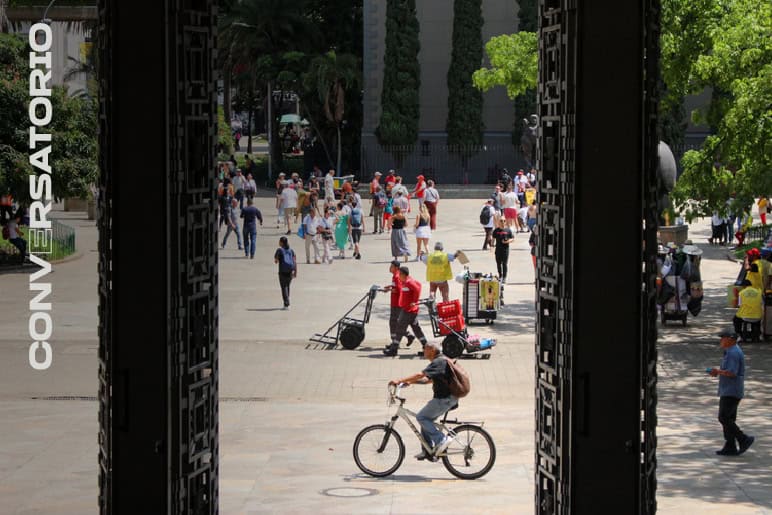 Realización de eventos y conferencias en espacios abiertos urbanos en Bogotá. Aquí, un escenario con muchas actividades, personas caminando, bicicletas y zonas verdes, ideal para eventos sociales y profesionales.