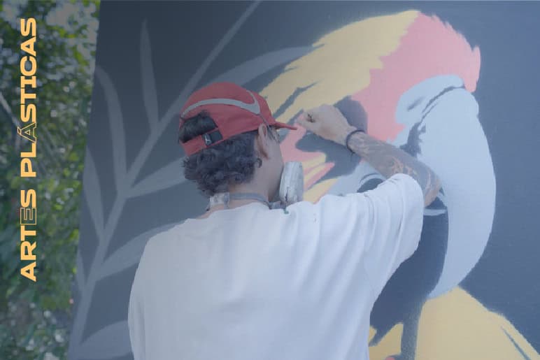 Dibujo de arte urbano en pared por artista urbano con gorra roja y tatuajes, creando una obra de arte en murales, estilo artística moderna y expresiva en la calle, evento de arte callejero en Colombia.