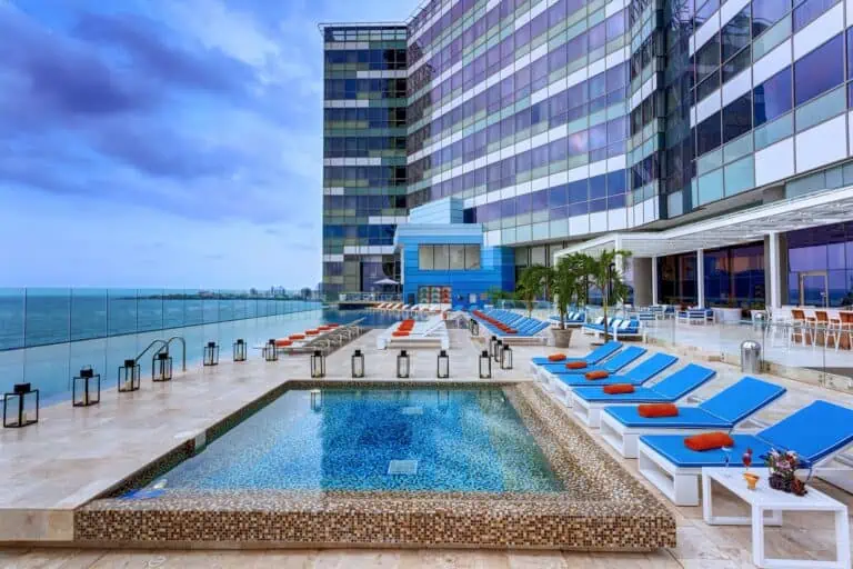 城市中的豪华酒店屋顶泳池，可欣赏海景，设有带日光浴床和遮阳伞的休息区，氛围现代优雅，是举办活动和放松的理想场所。