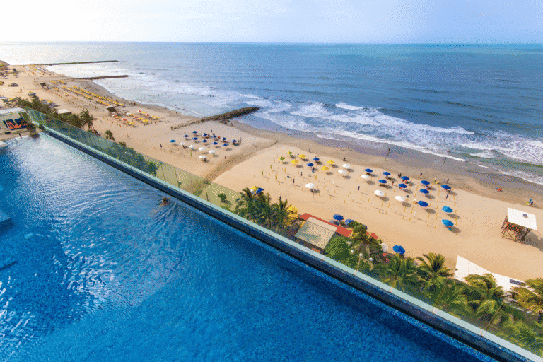 Espectacular vista aérea de una playa en Cartagena con un hotel que cuenta con piscina infinity y área para eventos, perfecta para organizar eventos corporativos en la playa.