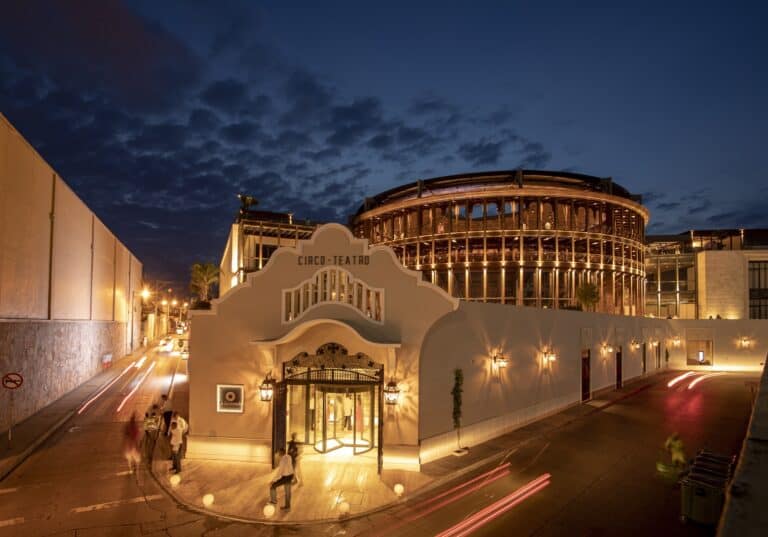 Cíaco-Teatro en un edificio moderno y luminoso en la noche, ideal para eventos y funciones culturales en Colombia, con iluminación cálida y ambiente sofisticado.