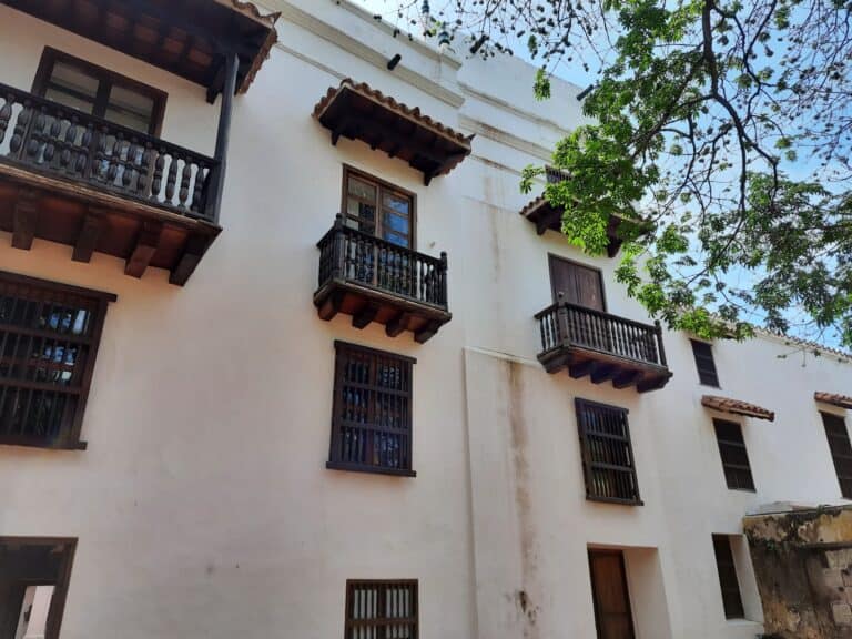 Balcones de madera en fachada blanca de edificio colonial en evento cultural en Medellín.