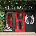 剧院入口处装饰着墙壁和红色铁门，招牌上有翅膀和植物，现代而引人注目的外观，适合卡塔赫纳的文化和戏剧活动。