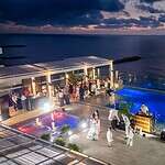 Fiesta en la azotea junto a piscina con vista al océano al atardecer en un evento exclusivo en Bogotá.