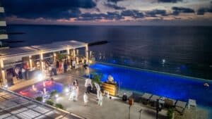 Fiesta en la azotea junto a piscina con vista al océano al atardecer en un evento exclusivo en Bogotá.