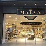 Moderno local de tienda de moda "Malva" en centro comercial con diseño elegante y exhibición de ropa y accesorios de alta calidad.