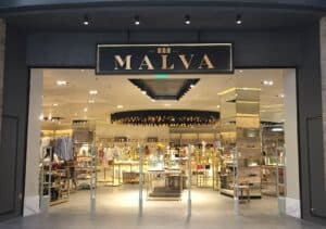 Moderno local de tienda de moda "Malva" en centro comercial con diseño elegante y exhibición de ropa y accesorios de alta calidad.