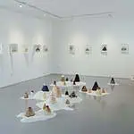 现代简约风格的画廊中，艺术风景画以小山和墙上的艺术作品为特色。