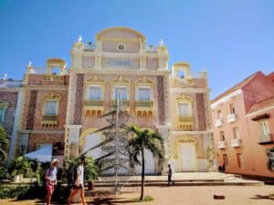 Edificio de teatro historicizado en Cartagena, Colombia, inspirado en arquitectura europea, con detalles en colores pastel y decoración clásica, ideal para eventos culturales y sociales.