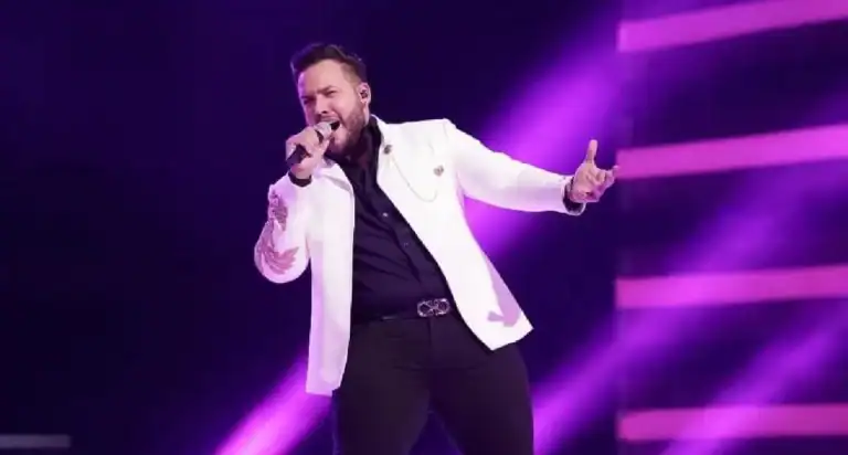 Espectáculo en vivo con cantante en el escenario, iluminación de luz morada y ambiente de concierto. Evento de entretenimiento musical y cultura en Colombia bajo la organización de Eventario.