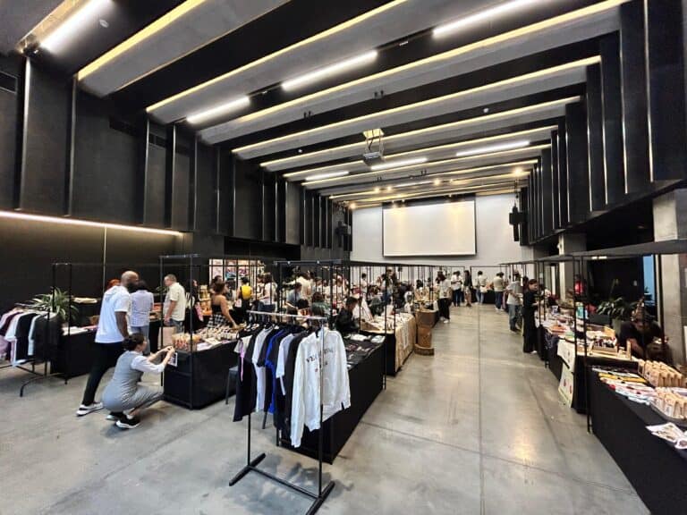 Bazar en un espacio amplio y moderno, con diferentes puestos de venta de ropa, accesorios y productos artesanales en un evento organizado por Eventario en Colombia.