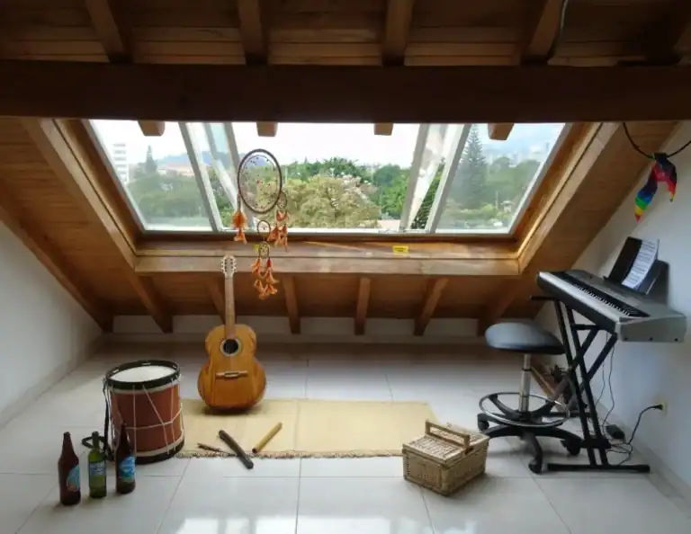Armoniosa habitación con instrumentos musicales, terraza con vista, ambiente acogedor y natural, ideal para eventos y reuniones creativas en Bogotá.