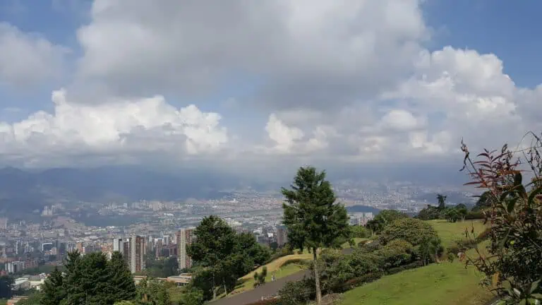 Farbenfroher Bildcode eines Panoramablicks auf die Stadt und die Berge, Stadtbild und Natur, Veranstaltungen und Tourismus in Kolumbien, Blick von einem Park oder Hügel an einem bewölkten Tag.